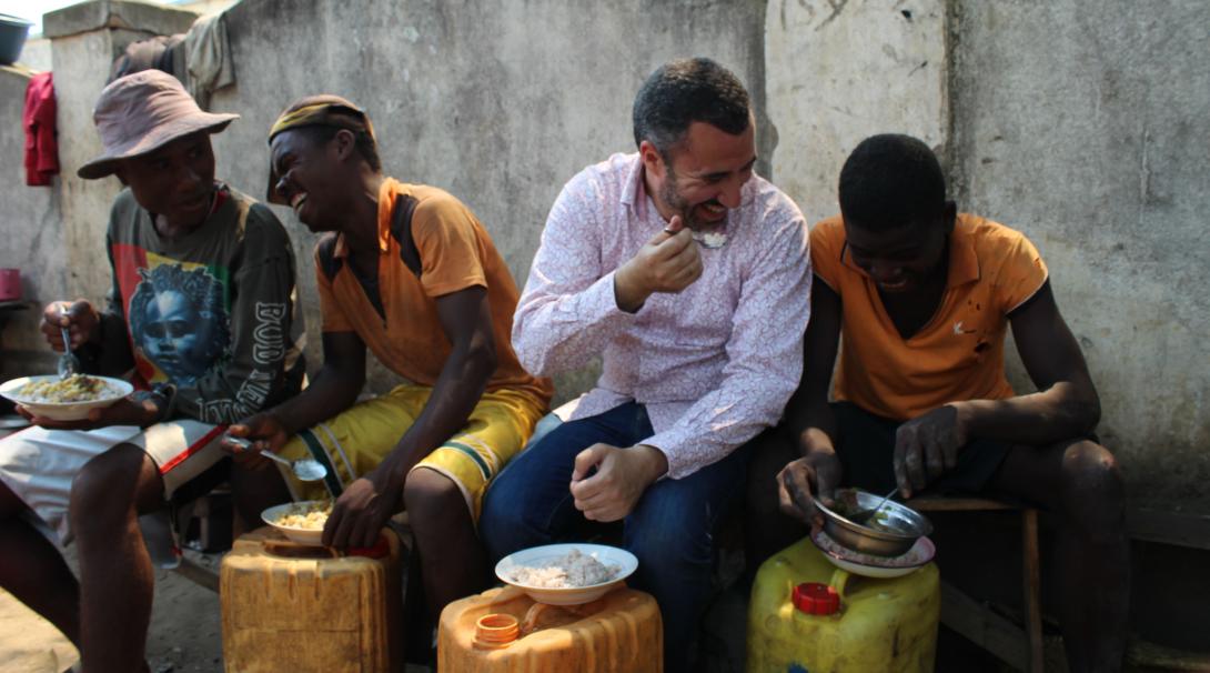 Un volontaire de Projects Abroad prend un repas végan avec des Malgaches Un volontaire et des Malgaches locaux dégustant un repas végan ensemble, en s'amusant.